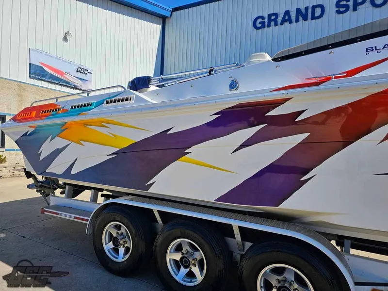 Slide: The Image of 2001 Black Thunder 43 GT Flat Deck boat with vibrant, colorful graphics on a trailer. - 9