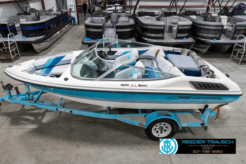 Slide: The Image of 1991 Chaparral 1800 SL boat on trailer in showroom, blue and white design. - 1
