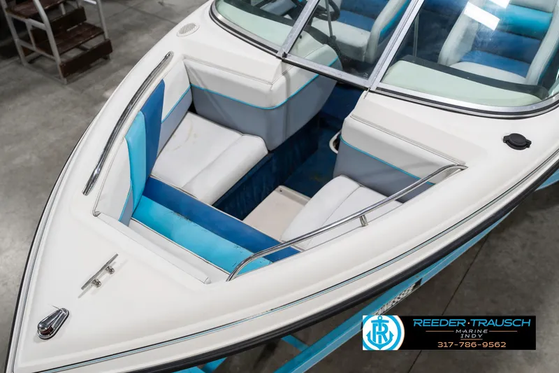 Slide: The Image of 1991 Chaparral 1800 SL boat interior with blue and white seating, displayed indoors. - 11