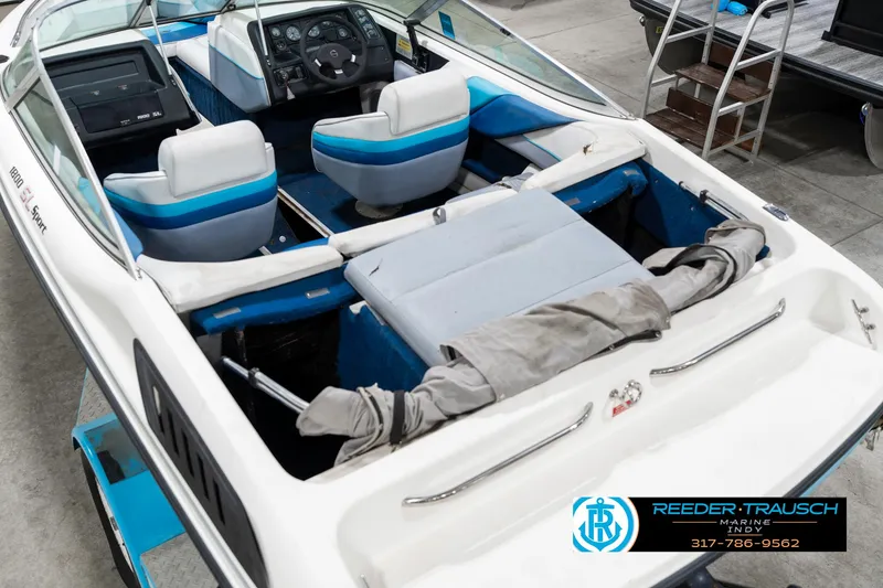 Slide: The Image of 1991 Chaparral 1800 SL boat interior with blue and white seating, steering console, and cover. - 14