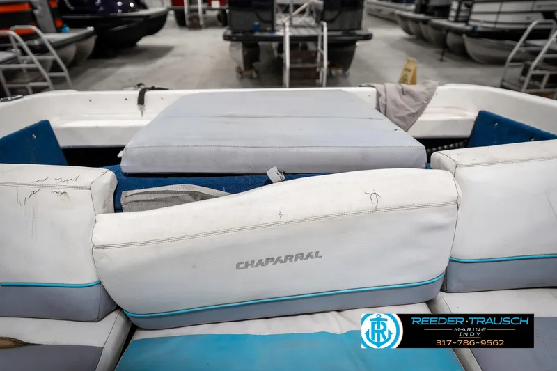 Slide: The Image of 1991 Chaparral 1800 SL boat interior with white and blue seating in a showroom. - 25