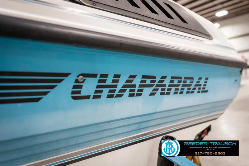 Slide: The Image of 1991 Chaparral 1800 SL boat with blue detailing in a showroom. - 46