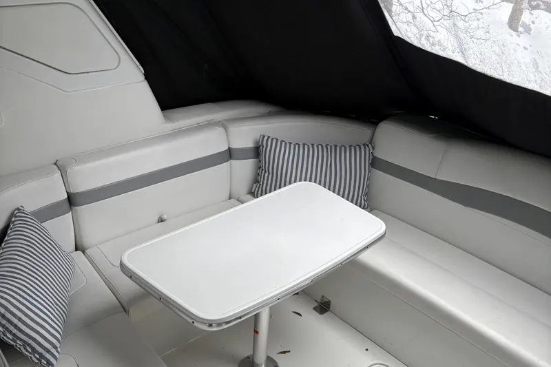 Slide: The Image of 2005 Formula 40pc boat interior with white seating, striped cushions, and a central table. - 13