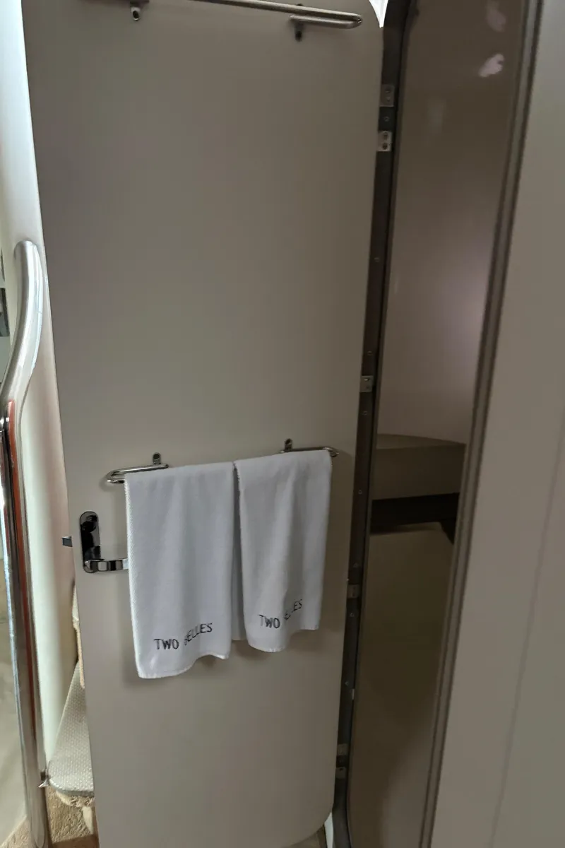 Slide: The Image of White door with towels in a 2005 Formula 40pc boat interior. - 25