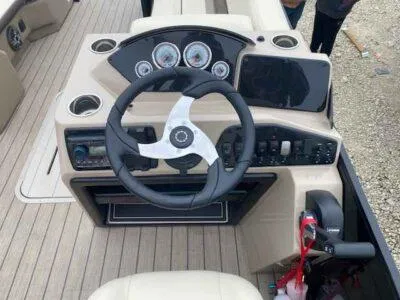 Slide: The Image of 2025 SunCatcher Select 322RC boat dashboard with steering wheel and control panel. - 5