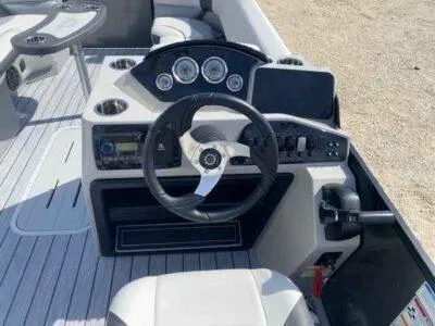 Slide: The Image of 2025 SunCatcher Select 322RC boat dashboard with steering wheel and control panel. - 5