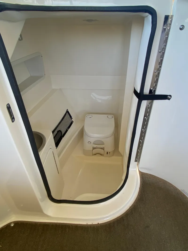 Slide: The Image of 2016 Sea Ray 270 Sundeck boat interior with compact marine toilet. - 10