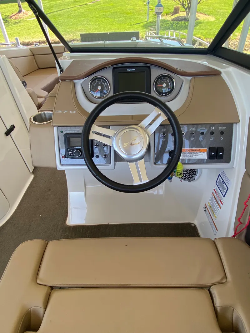 Slide: The Image of 2016 Sea Ray 270 Sundeck boat interior with steering wheel and dashboard controls. - 3