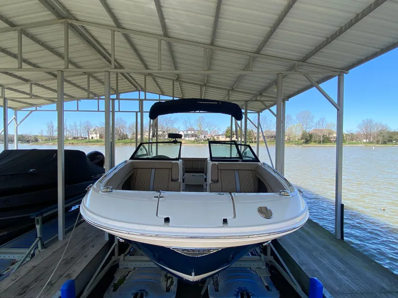 Slide: The Image of 2016 Sea Ray 270 Sundeck boat docked under a covered structure by the water. - 6