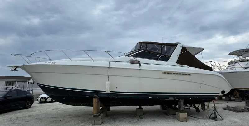 Slide: The Image of 1995 Silverton Express boat on dry dock under cloudy skies. - 0