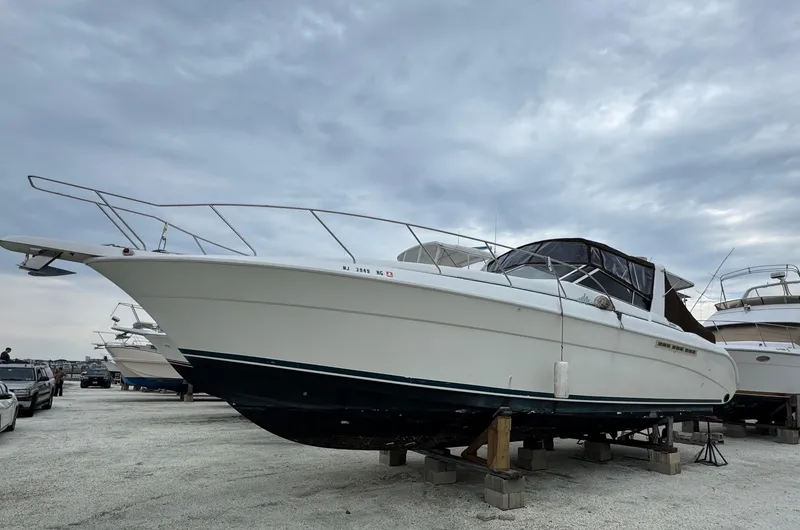 Slide: The Image of 1995 Silverton Express boat on dry dock under cloudy sky. - 1