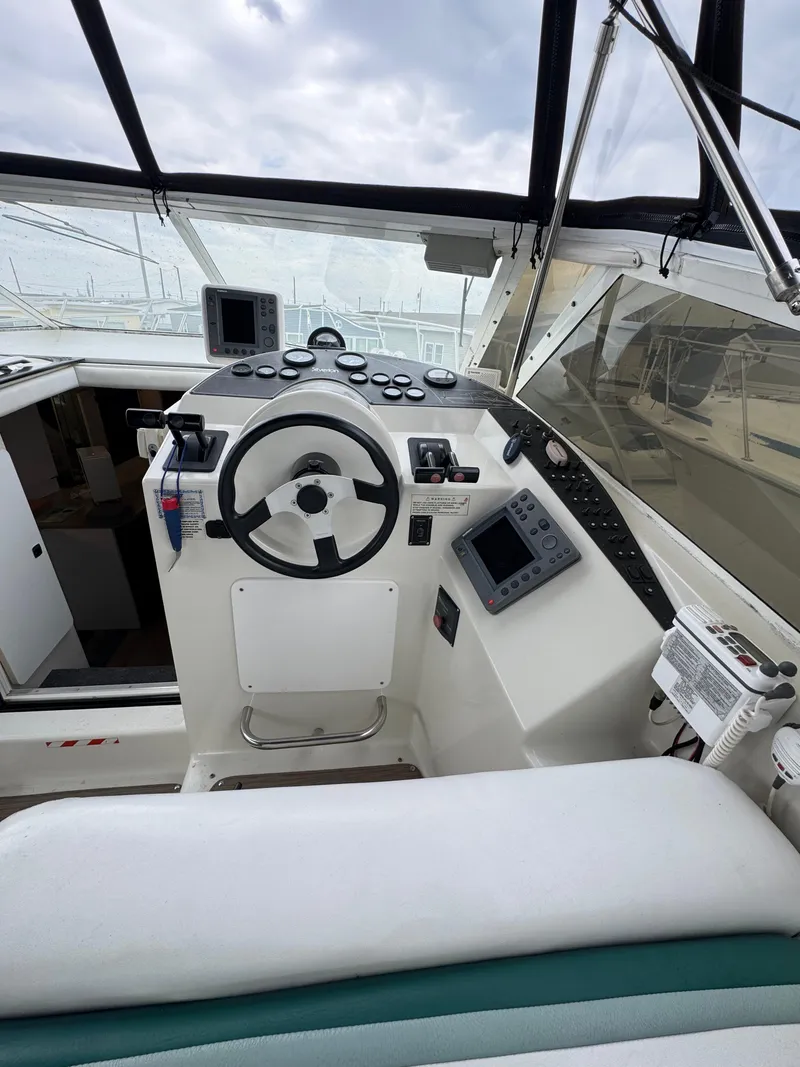 Slide: The Image of 1995 Silverton Express boat cockpit with steering wheel and navigation instruments. - 10