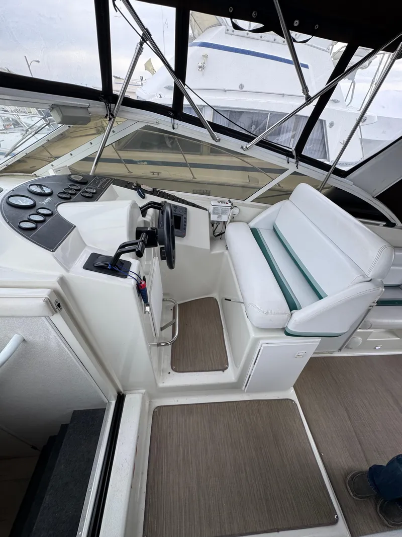 Slide: The Image of 1995 Silverton Express boat cockpit with steering wheel and white seating. - 12