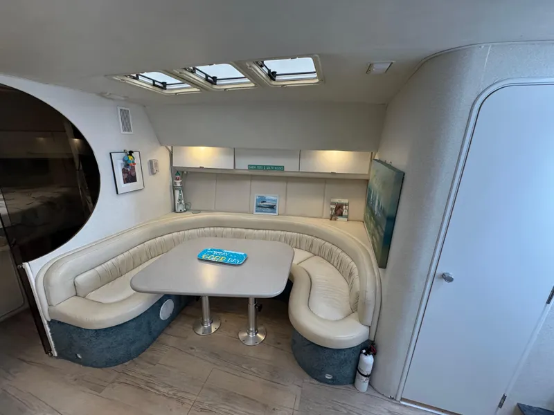Slide: The Image of Interior of a 1995 Silverton Express yacht with a cozy dining area and skylights. - 15