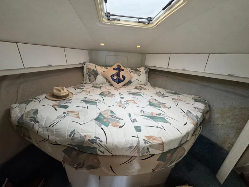 Slide: The Image of Cozy cabin interior of a 1995 Silverton Express boat with patterned bedding and nautical decor. - 16