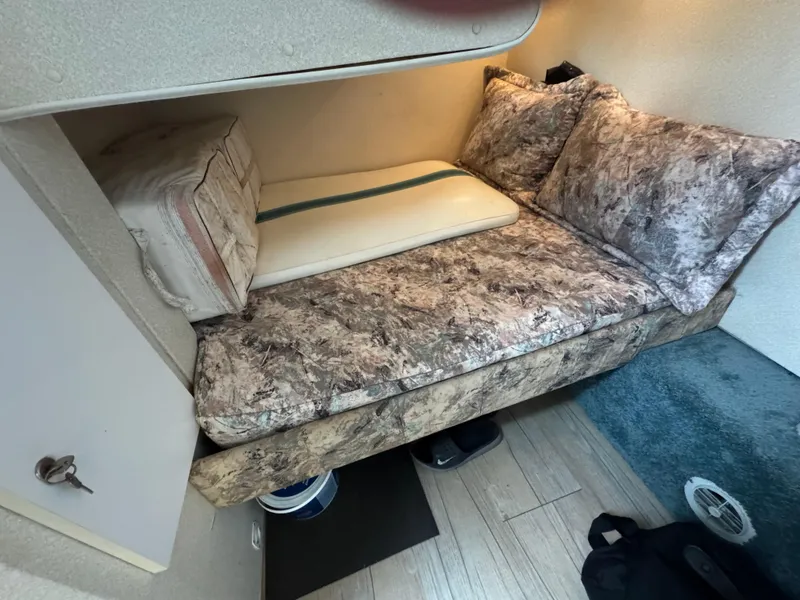 Slide: The Image of Cozy sleeping area in a 1995 Silverton Express boat with patterned cushions. - 17