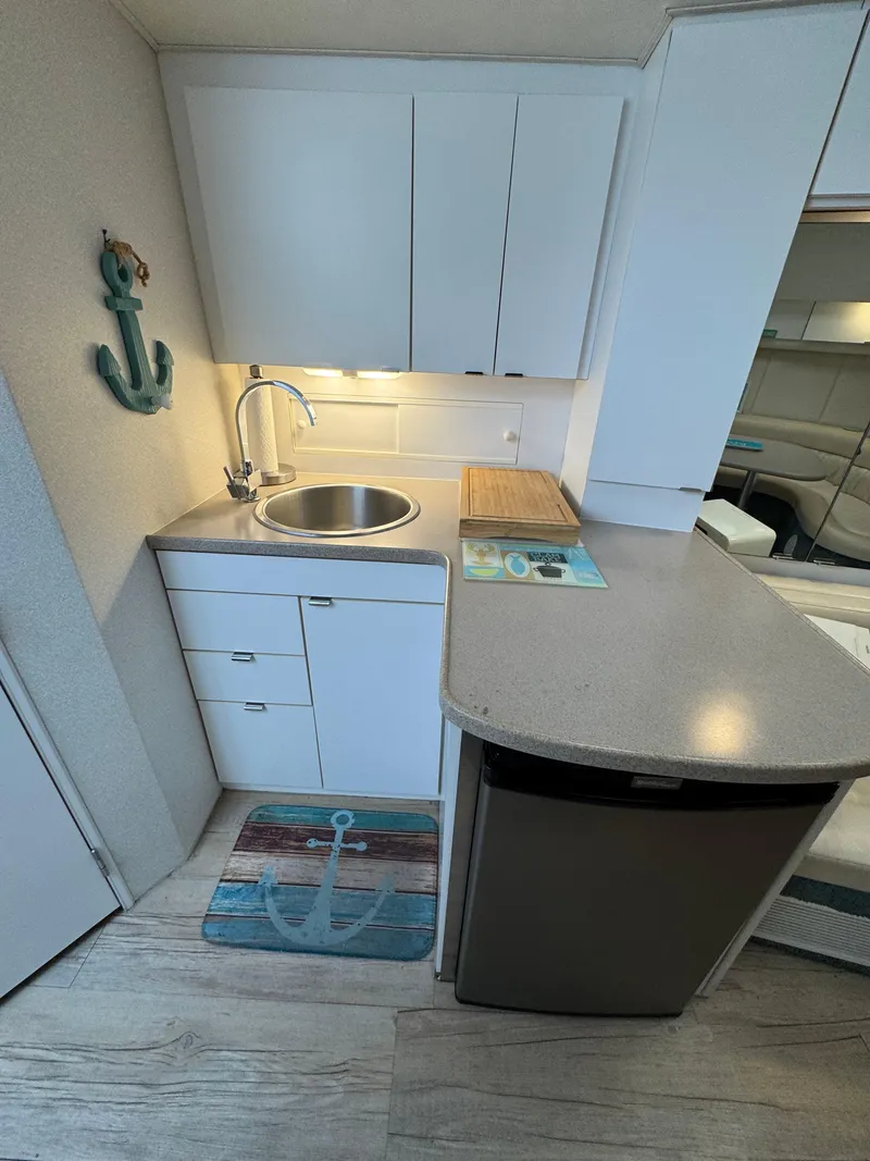 Slide: The Image of 1995 Silverton Express boat kitchen with sink, cabinets, and nautical decor. - 18