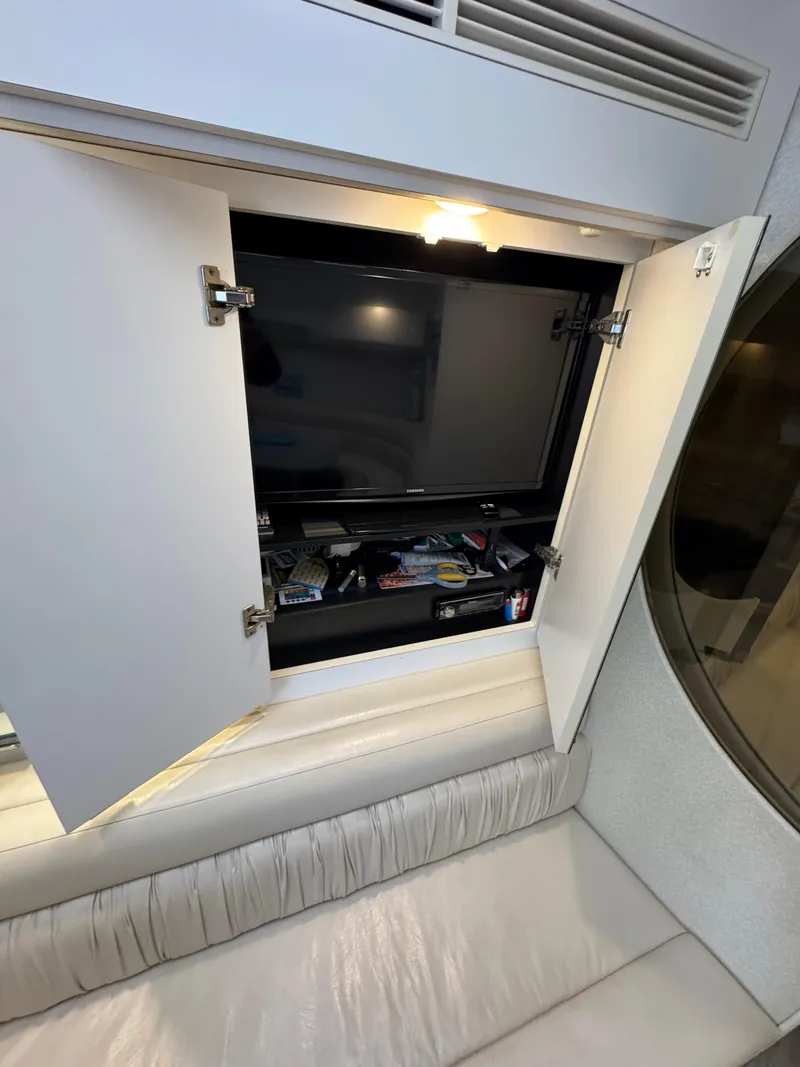 Slide: The Image of Cabinet with TV and storage inside a 1995 Silverton Express boat. - 19