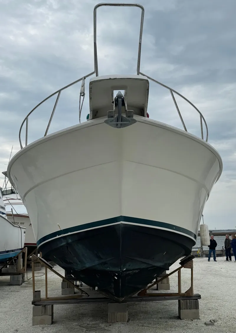 Slide: The Image of 1995 Silverton Express boat on dry dock, viewed from the front under cloudy skies. - 2