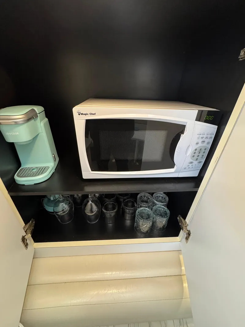 Slide: The Image of Cabinet with microwave, coffee maker, and glassware on a Silverton Express 1995 boat. - 20