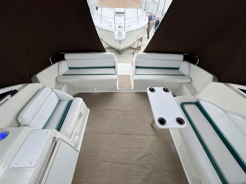 Slide: The Image of 1995 Silverton Express boat interior with white seating and table, docked at marina. - 7
