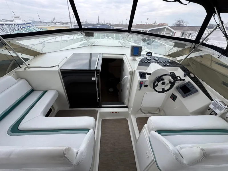 Slide: The Image of 1995 Silverton Express boat cockpit with steering wheel, seating, and navigation equipment. - 9