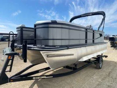 Slide: The Image of 2025 SunCatcher Select 320 RC pontoon boat on trailer, parked outdoors. - 2