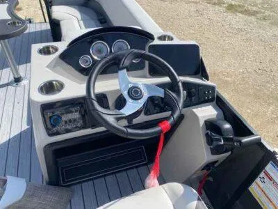 Slide: The Image of 2025 SunCatcher Select 320 RC boat dashboard with steering wheel and control panel. - 6