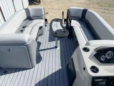 Slide: The Image of 2025 SunCatcher Select 320 RC pontoon boat interior with gray seating and central table. - 8