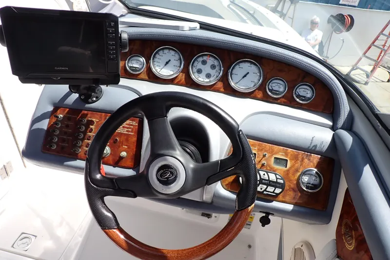 Slide: The Image of Steering wheel and dashboard of a 2002 Cobalt 240 boat with gauges and controls. - 11