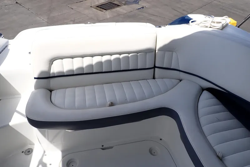 Slide: The Image of 2002 Cobalt 240 boat interior with white cushioned seating. - 19
