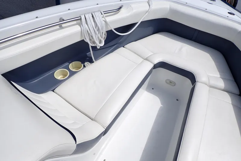 Slide: The Image of 2002 Cobalt 240 boat interior with white seating and cup holders. - 22