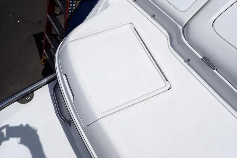 Slide: The Image of 2002 Cobalt 240 boat deck with storage compartment, white surface, and railing. - 25
