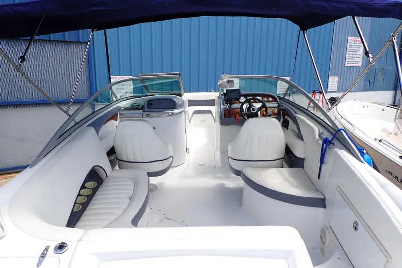 Slide: The Image of 2002 Cobalt 240 boat interior with white seating and blue canopy. - 3