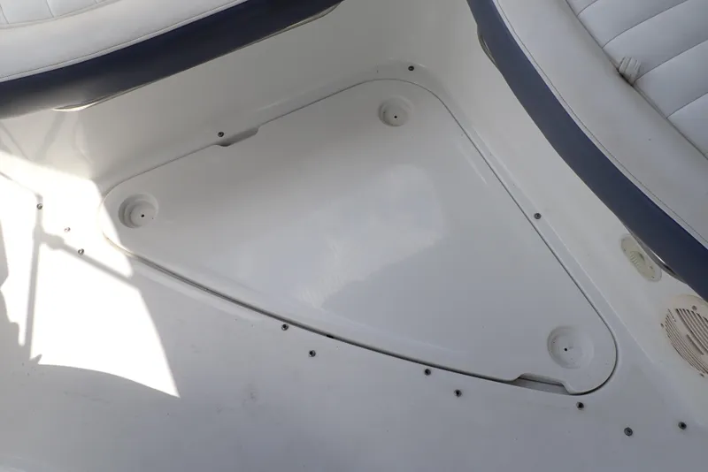 Slide: The Image of Interior view of a 2002 Cobalt 240 boat, featuring white seating and storage area. - 38