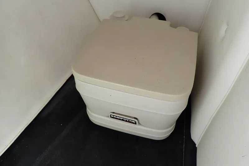 Slide: The Image of Portable toilet in a 2002 Cobalt 240 boat interior. - 48
