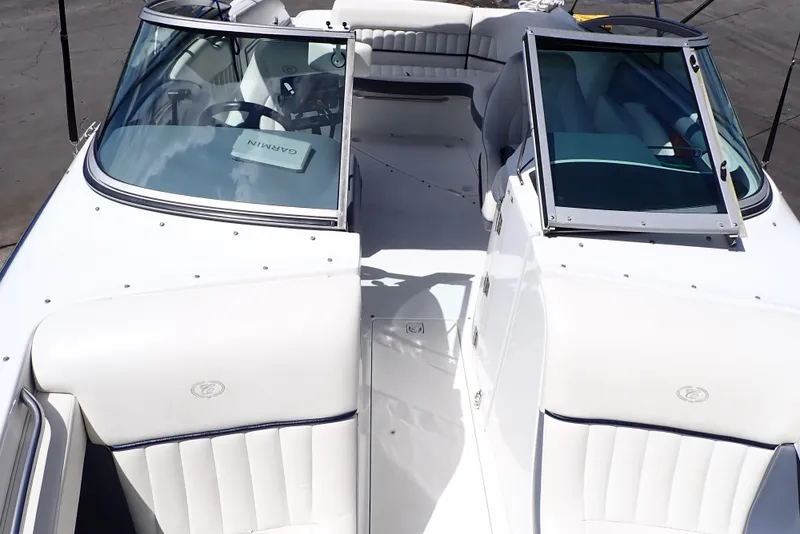 Slide: The Image of 2002 Cobalt 240 boat interior with white seating and open windshield. - 8