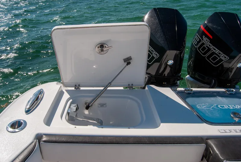 Slide: The Image of 2023 Crevalle 33 CSF boat with open storage compartment and dual outboard engines. - 12