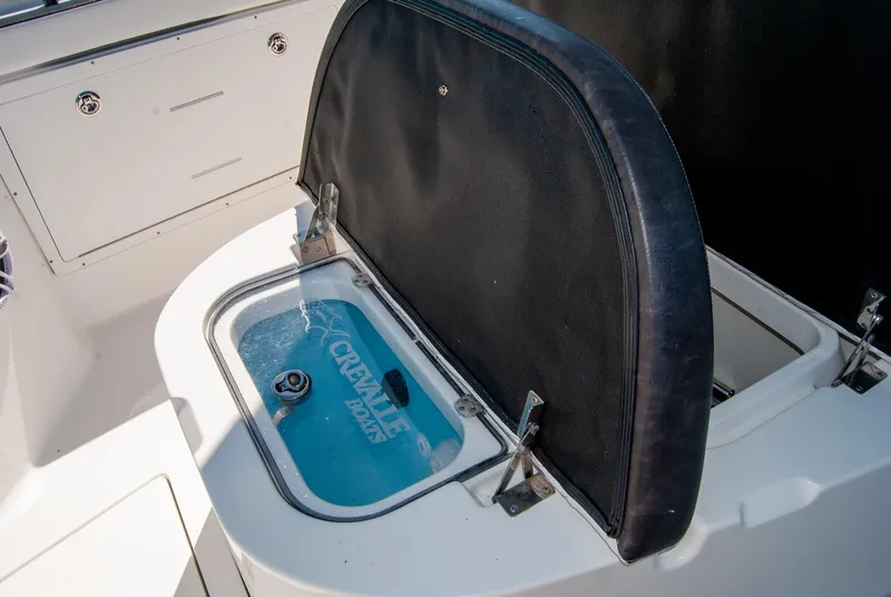 Slide: The Image of 2023 Crevalle 33 CSF boat with open storage compartment and visible branding. - 25