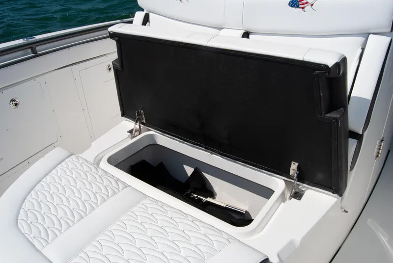 Slide: The Image of 2023 Crevalle 33 CSF boat with open storage compartment and cushioned seating. - 26