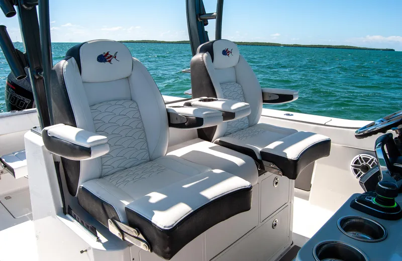 Slide: The Image of 2023 Crevalle 33 CSF boat seats with armrests, set against a scenic ocean backdrop. - 3