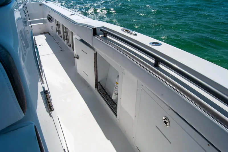 Slide: The Image of 2023 Crevalle 33 CSF boat deck with storage compartments, on clear blue water. - 31