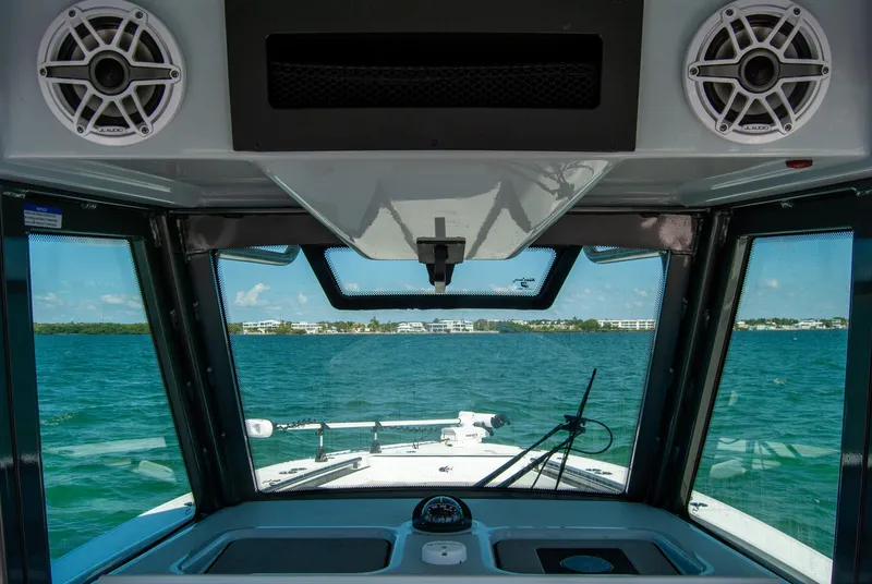 Slide: The Image of Interior view of 2023 Crevalle 33 CSF boat, showcasing dashboard and ocean scenery. - 35