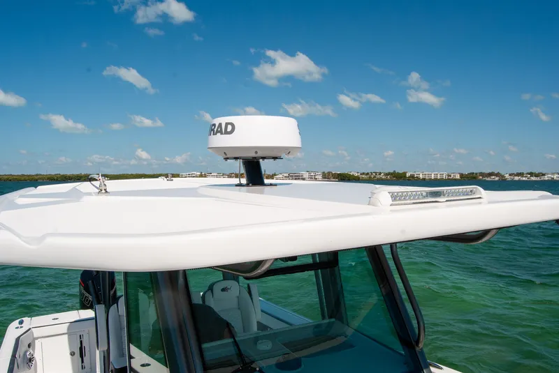 Slide: The Image of 2023 Crevalle 33 CSF boat with radar, cruising on clear blue water. - 36