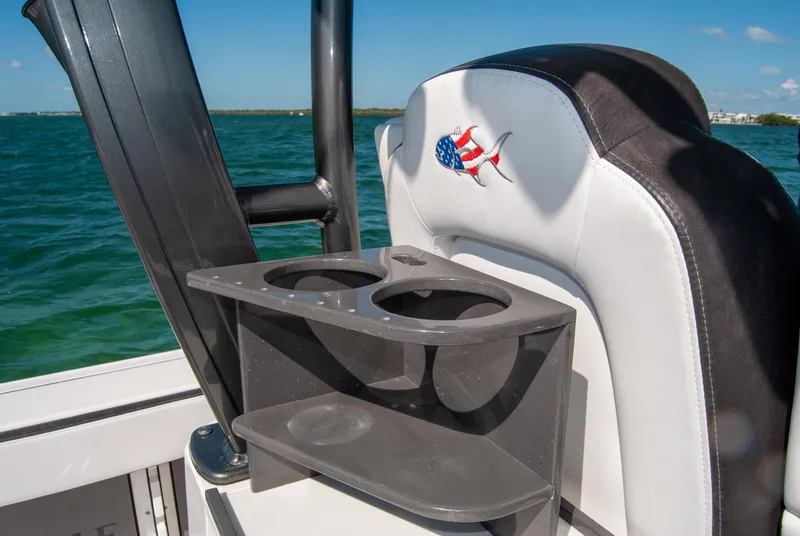 Slide: The Image of 2023 Crevalle 33 CSF boat seat with cup holders, ocean view in background. - 39