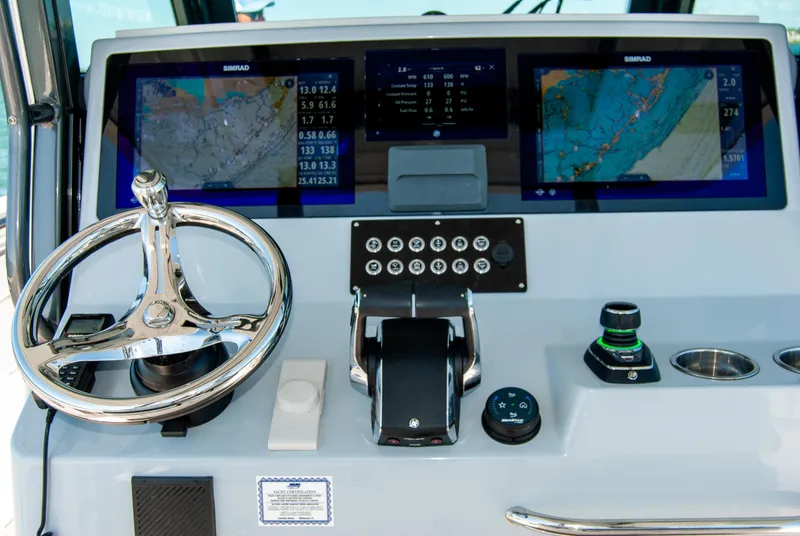 Slide: The Image of 2023 Crevalle 33 CSF boat dashboard with navigation screens and steering wheel. - 4
