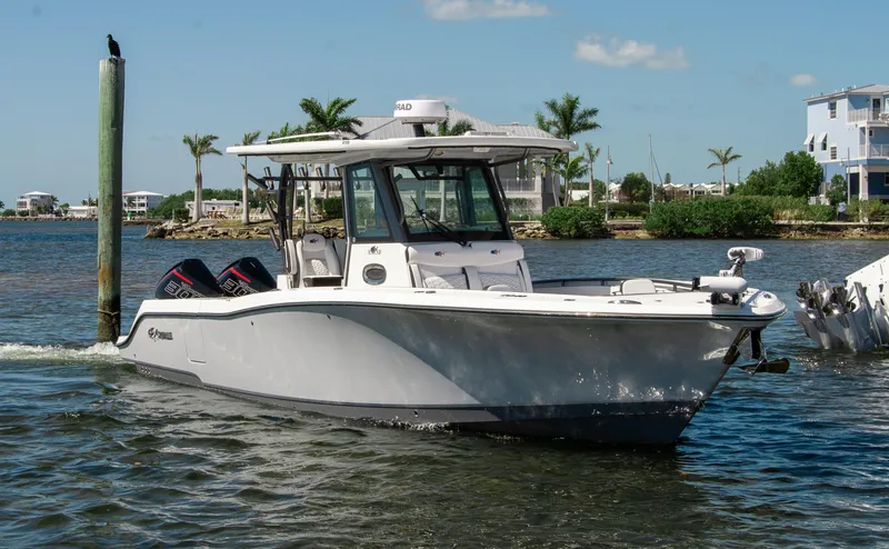 Slide: The Image of 2023 Crevalle 33 CSF boat on water near dock, clear sky, and palm trees. - 66