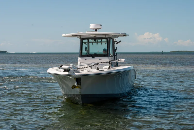 Slide: The Image of 2023 Crevalle 33 CSF boat navigating in calm waters under a clear blue sky. - 68