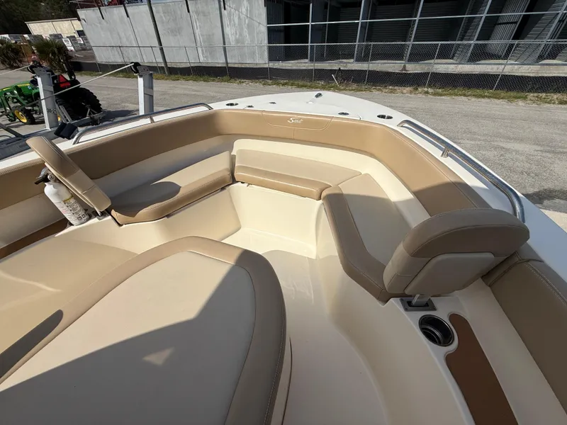 Slide: The Image of 2023 Scout 215 XSF boat interior with beige seating and cup holders. - 18