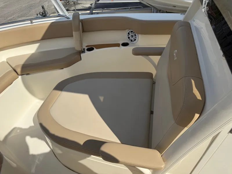 Slide: The Image of 2023 Scout 215 XSF boat interior with beige seating and speaker. - 22